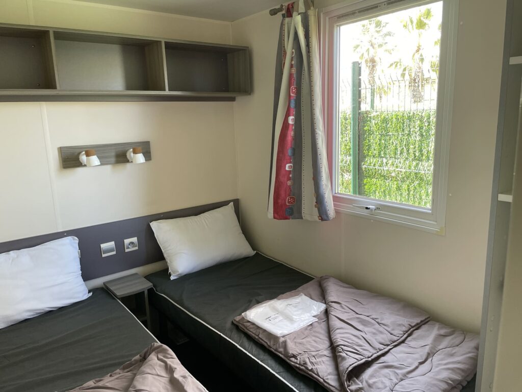 Visite et réservation du Mobil home XL à Vendres Plage dans l'Hérault pour location de vacances coin chambre